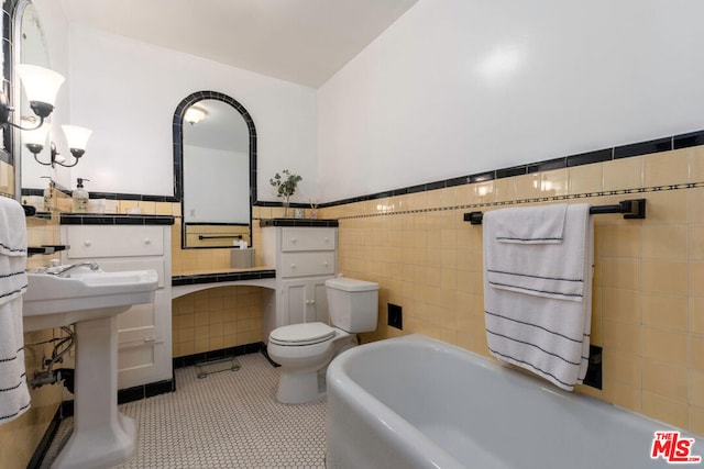 bathroom with toilet, tile patterned flooring, a bathing tub, and tile walls