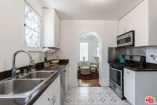 kitchen with sink, white cabinets, and appliances with stainless steel finishes