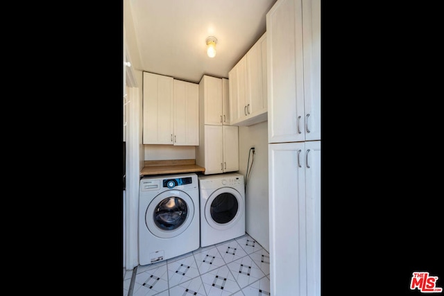 laundry area with independent washer and dryer and cabinets