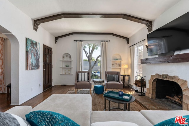 living room featuring built in shelves, vaulted ceiling with beams, and dark hardwood / wood-style flooring