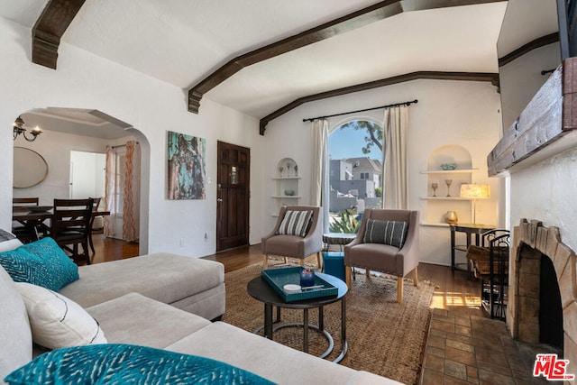 living room with built in features and vaulted ceiling