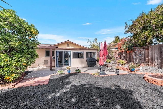 rear view of property with an outdoor fire pit and a patio area