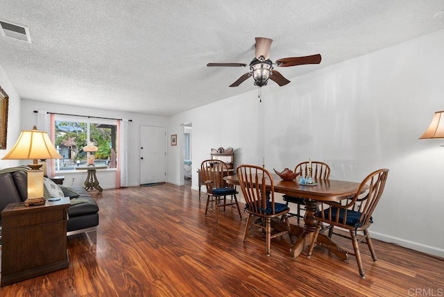 dining area featuring ceiling fan, dark wood-type flooring, and a textured ceiling