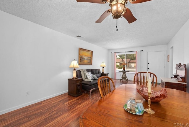 dining space with ceiling fan, hardwood / wood-style floors, and a textured ceiling