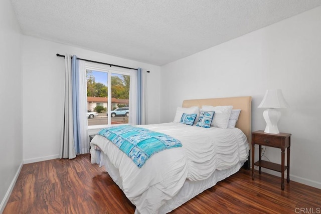 bedroom featuring dark wood-type flooring and a textured ceiling