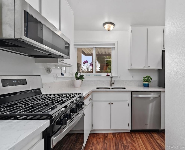 kitchen with stainless steel appliances, sink, white cabinets, and dark hardwood / wood-style floors