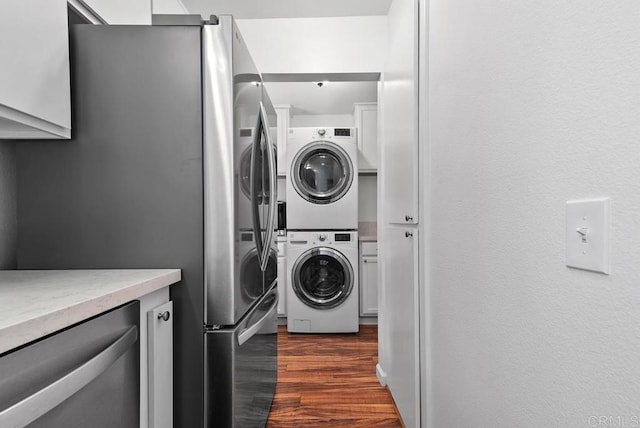 laundry area featuring dark wood-type flooring and stacked washer and clothes dryer