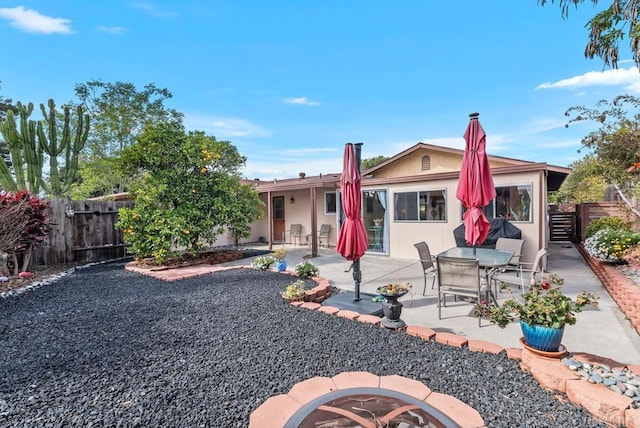 back of property with an outdoor fire pit and a patio area