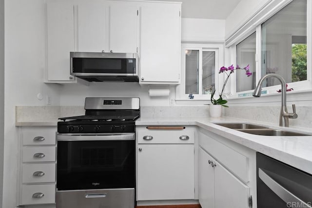 kitchen featuring appliances with stainless steel finishes, sink, and white cabinets