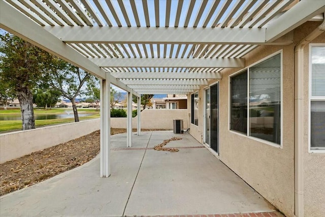 view of patio with a pergola and a water view