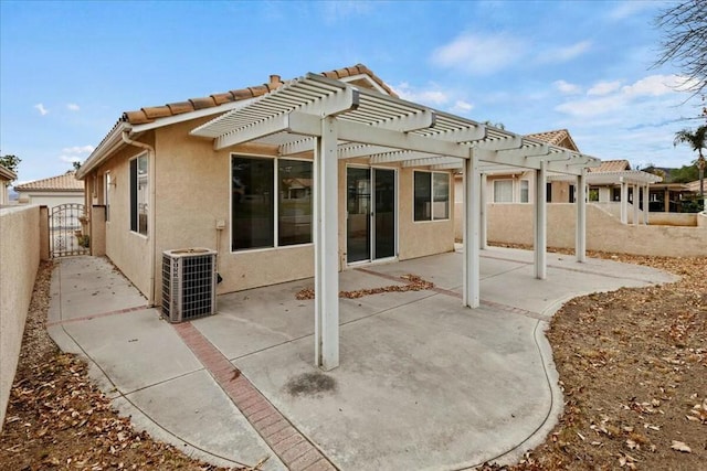 rear view of property with a pergola, a patio area, and central air condition unit