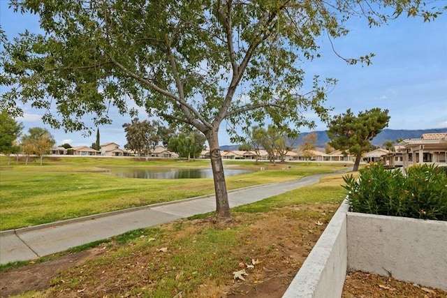 view of home's community featuring a lawn and a water view