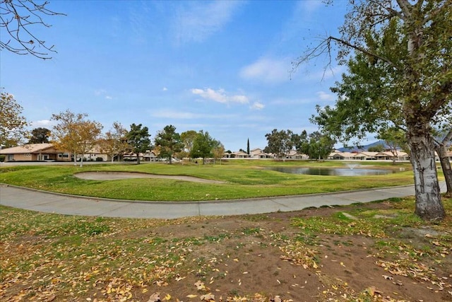 view of property's community with a water view and a yard