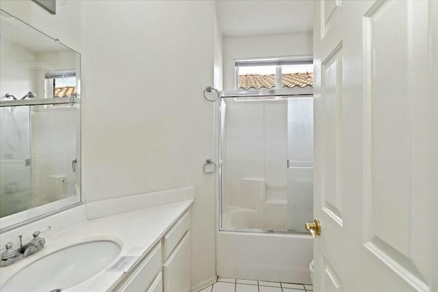 bathroom featuring tile patterned flooring, vanity, and shower / bath combination with glass door