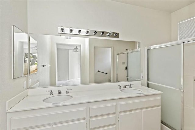 bathroom with vanity, ceiling fan, and a shower with door