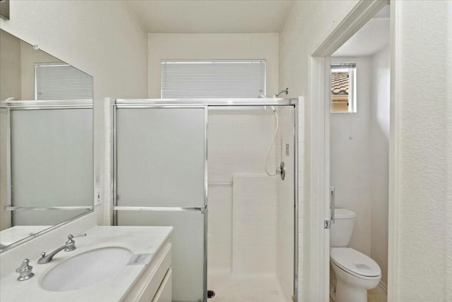 bathroom featuring vanity, toilet, and an enclosed shower