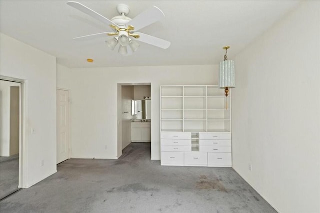 unfurnished bedroom featuring ceiling fan, a closet, light colored carpet, and ensuite bath