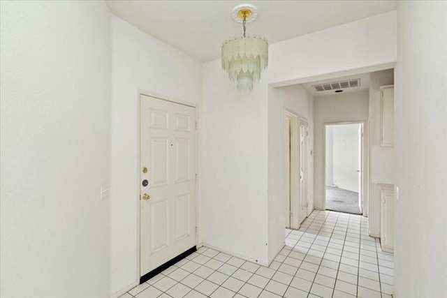 tiled foyer featuring a chandelier