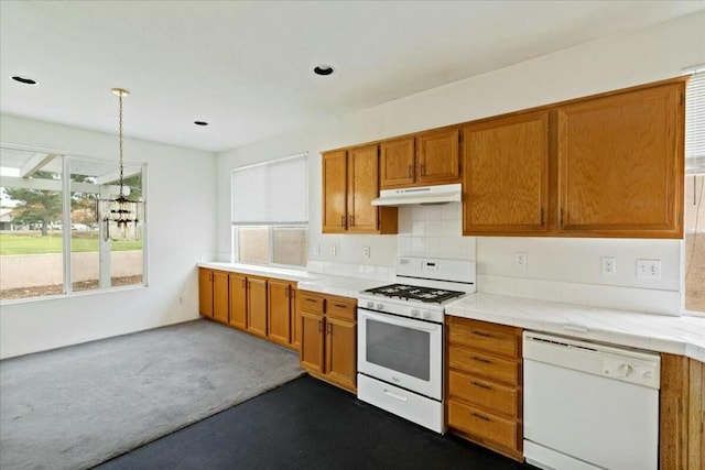 kitchen with tasteful backsplash, dark carpet, white appliances, decorative light fixtures, and tile counters