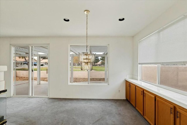 unfurnished dining area featuring light carpet and a notable chandelier