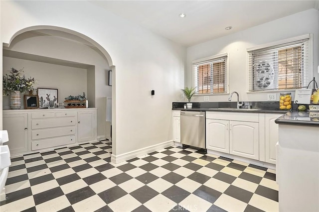 kitchen featuring stainless steel dishwasher, white cabinetry, and sink