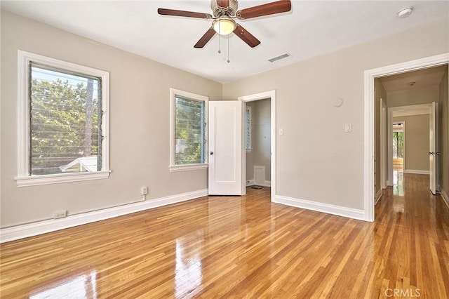 unfurnished bedroom featuring multiple windows, ceiling fan, and light hardwood / wood-style floors