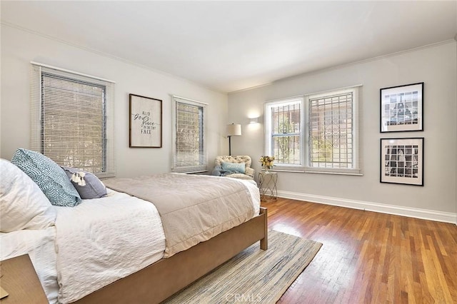 bedroom with hardwood / wood-style floors and ornamental molding