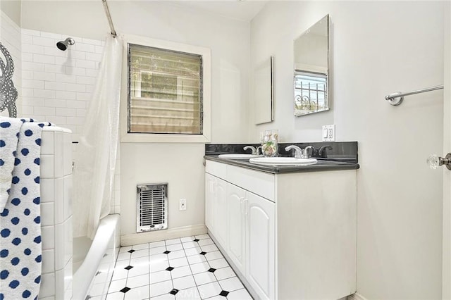 bathroom featuring heating unit, shower / bath combo with shower curtain, and vanity