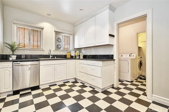 kitchen with washing machine and clothes dryer, sink, a healthy amount of sunlight, stainless steel dishwasher, and white cabinets