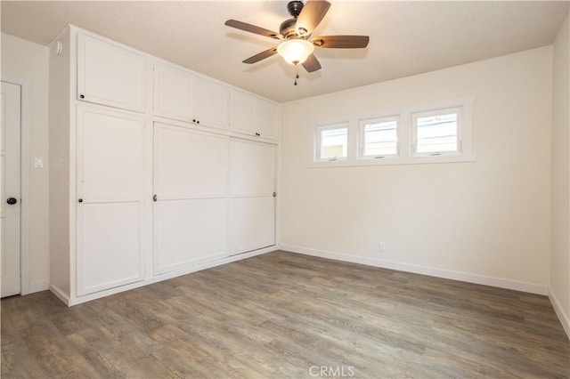 unfurnished bedroom with hardwood / wood-style flooring, ceiling fan, and a closet