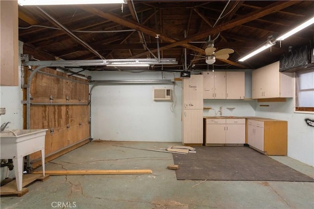 garage with a wall mounted AC, ceiling fan, and sink