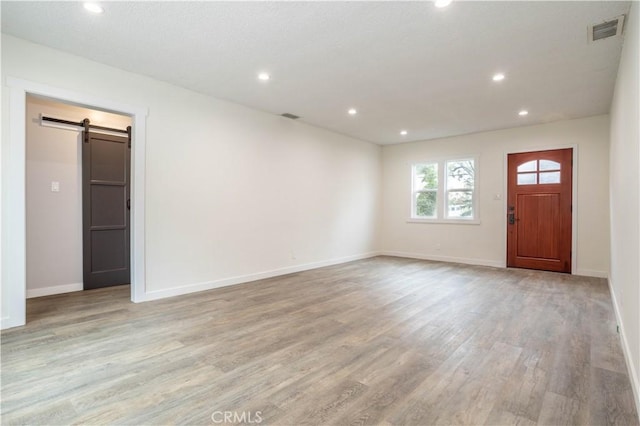 interior space featuring a barn door and light hardwood / wood-style flooring