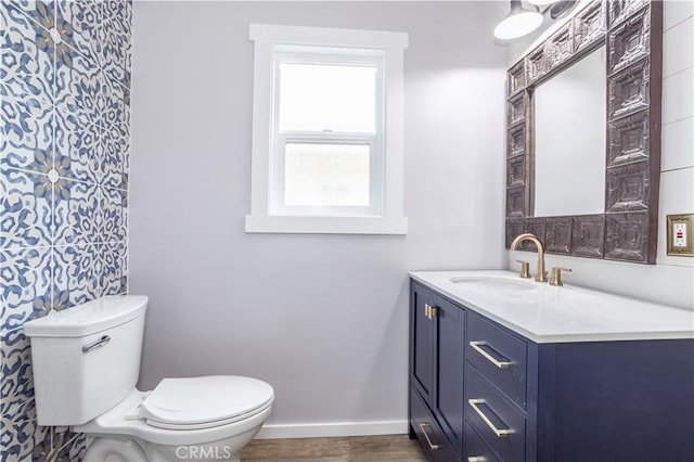 bathroom with vanity, toilet, and wood-type flooring