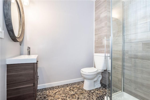 bathroom featuring tile patterned floors, vanity, toilet, and a shower with shower door