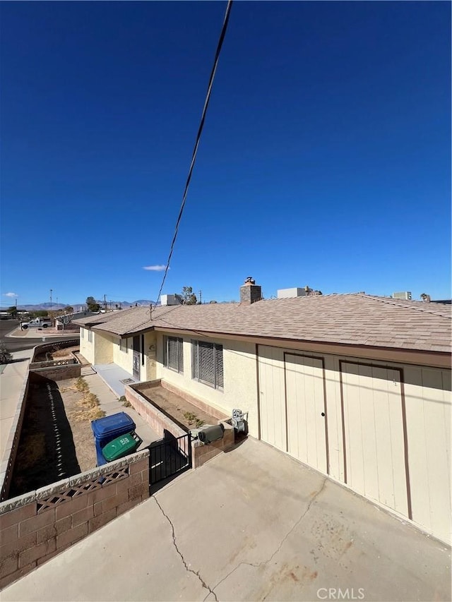 rear view of property with fence and roof with shingles