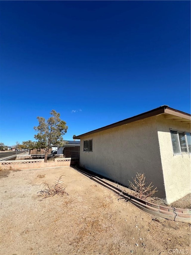 view of side of home with stucco siding