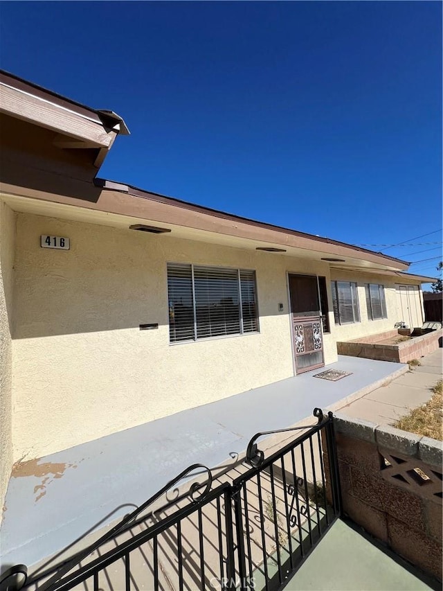 doorway to property featuring stucco siding