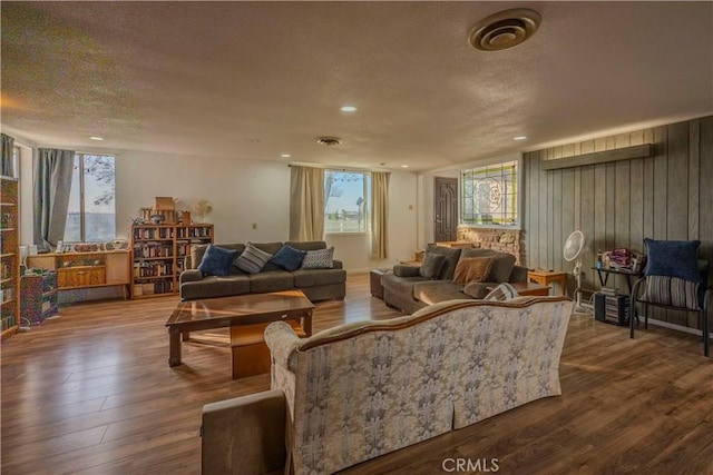 living room with plenty of natural light, wood-type flooring, and a textured ceiling