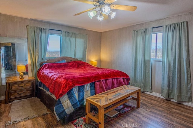 bedroom featuring multiple windows, ceiling fan, and hardwood / wood-style flooring