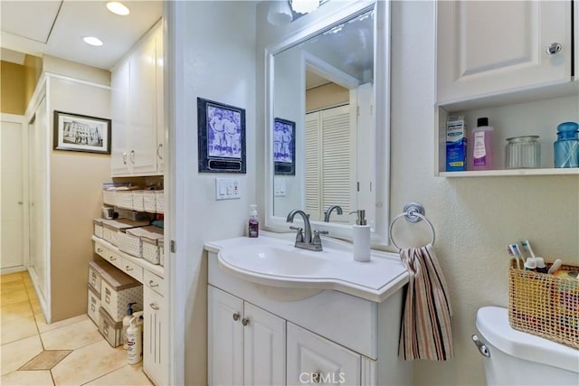 bathroom with tile patterned flooring, vanity, and toilet