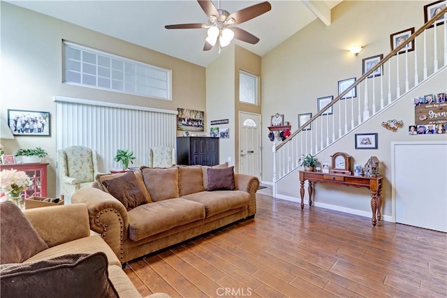 living room with beamed ceiling, ceiling fan, wood-type flooring, and high vaulted ceiling