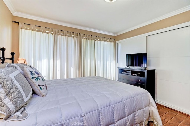 bedroom with multiple windows, crown molding, and wood-type flooring