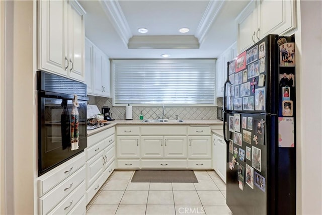 kitchen featuring black appliances, white cabinets, a raised ceiling, sink, and light tile patterned flooring