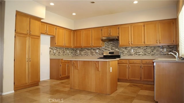 kitchen with tasteful backsplash, stainless steel range, a kitchen island, and sink