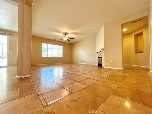 empty room featuring ceiling fan, a healthy amount of sunlight, and light tile patterned flooring