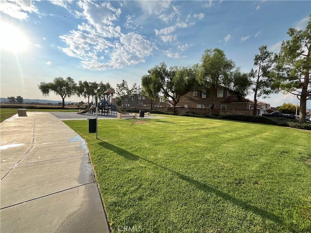 surrounding community featuring a playground and a lawn