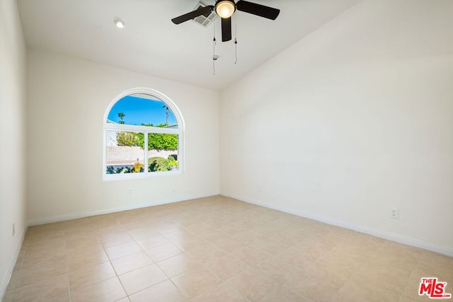 tiled spare room featuring vaulted ceiling and ceiling fan