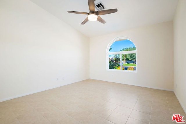 empty room with ceiling fan, lofted ceiling, and light tile patterned flooring