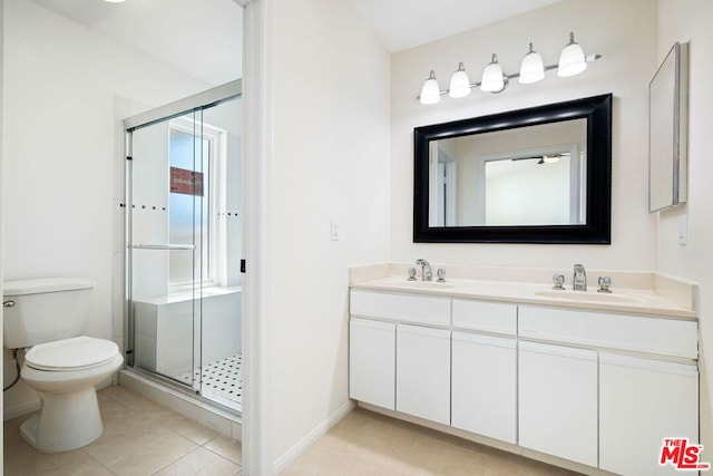 bathroom featuring vanity, toilet, a shower with shower door, and plenty of natural light