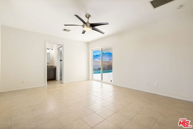 tiled spare room featuring ceiling fan